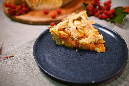 感恩节晚餐时，一块美国经典南瓜派的特写，外皮酥脆，放在海军盘上