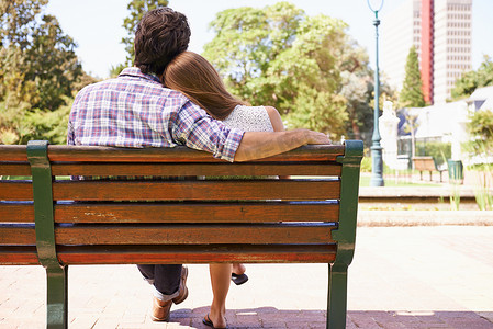 分享时刻摄影照片_我希望 20 年后还能来到这里……后视镜头中，一对年轻夫妇坐在公园的长椅上分享着温柔的时刻。