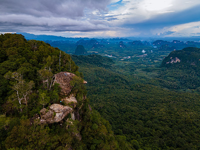 泰国甲米的龙冠山，一位年轻的旅行者坐在悬于深渊的岩石上，风景秀丽。 