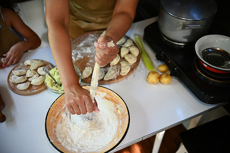 顶视图家庭主妇揉面团，把手放在装有面粉的搪瓷碗上，在乡村厨房煮饺子