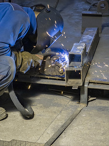 在制造重工业工厂、室内与钢金属、铁、火花设备进行焊接工作