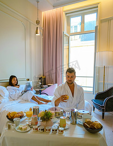 法国的卧室摄影照片_早晨在巴黎的床上醒来，早餐咖啡和报纸，男人和女人 honemoon