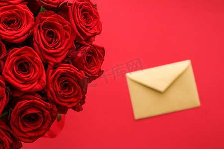 艺术传达摄影照片_情人节情书和鲜花递送服务、豪华红玫瑰花束和红色背景的卡片信封