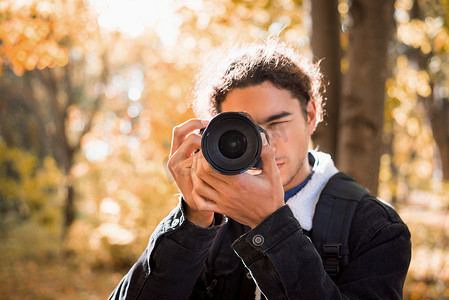 年轻摄影师在城市公园拍摄自然风光