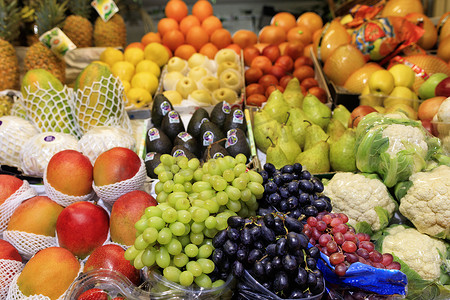 芒果凤梨摄影照片_葡萄、芒果、梨、苹果、菠萝、甜瓜的绿黑红浆果在市场上出售
