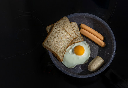 越南菜摄影照片_用煎锅准备早餐，包括煎鸡蛋、煎香肠、面包和越南猪肉。