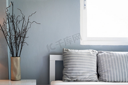 古典枕头摄影照片_舒适的客厅，带窗户的沙发上的灰色枕头，复印