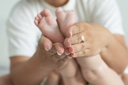 可爱手脚摄影照片_父母握着新生婴儿的手脚
