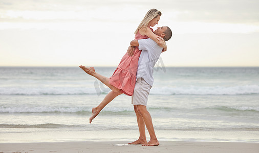 异族情侣，在大自然的假期里，在水边的海滩上爱和拥抱。