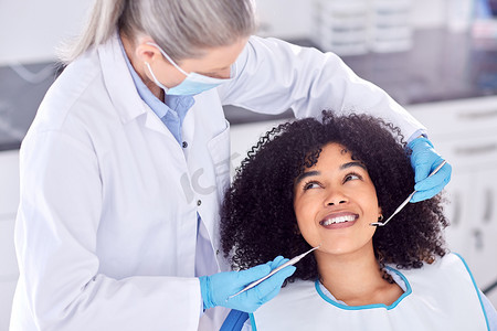 .. 一名年轻女性患者在牙医处检查牙齿的照片。