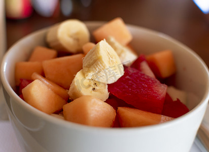 水果色拉摄影照片_一碗水果沙拉，香蕉沙拉水果特写，健康水果概念