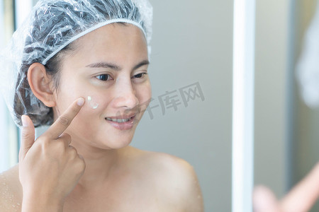 涂霜摄影照片_女人用手在脸上涂霜，感觉快乐、健康