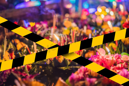 注意黄色胶带摄影照片_Loy Krathong 节，人们购买鲜花和蜡烛点燃并漂浮在水上，以庆祝泰国 Covid-19 检疫黄色胶带的 Loy Krathong 节。