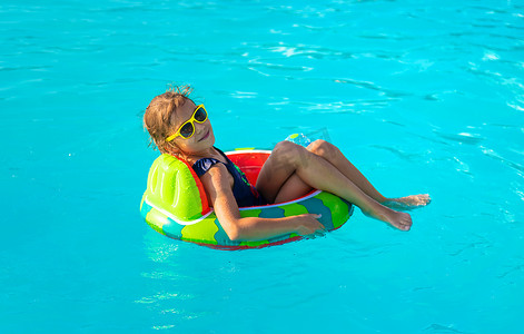 一个孩子围成一圈在游泳池里游泳。