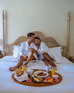 一对中年男女在毛里求斯豪华酒店公寓的卧室里吃早餐