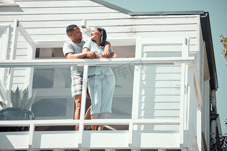 穿着睡衣的爱年轻的混血情侣在新家的阳台上或在度假享受蜜月时，深情地看着彼此的眼睛，分享浪漫的时刻