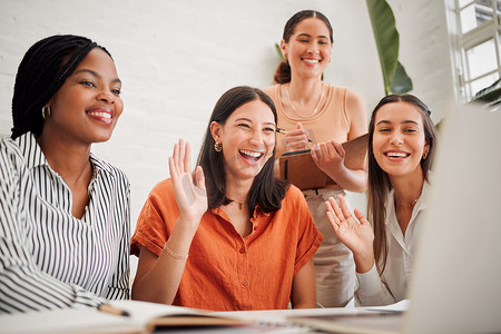 在办公室会议室的笔记本电脑上通过视频通话，在虚拟电话会议期间，一群不同的商业女性向同事们打招呼。