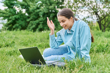 女高中生摄影照片_十几岁的女高中生坐在绿草上使用笔记本电脑