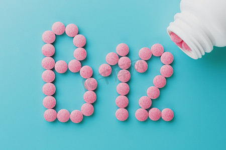 B12 形式的粉红色药片在白色罐头的蓝色背景上特写，低对比度