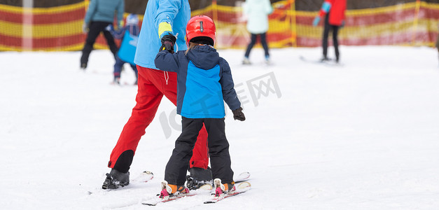 洞察大师摄影照片_冬季运动学校儿童滑雪大师班与教练。