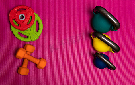运动重量杆红色哑铃黄色蓝绿色杠铃，概念健康生活方式健身房生活方式从房间毛巾锻炼、教练举重。