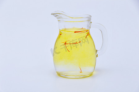 从红色雄蕊的藏红花茶在一个透明水罐在白色背景。