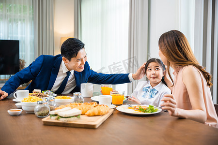 亚洲家庭的父亲、有孩子的母亲早上在餐桌厨房吃早餐