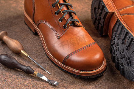 手工制作的棕色皮鞋，配有补鞋匠工具