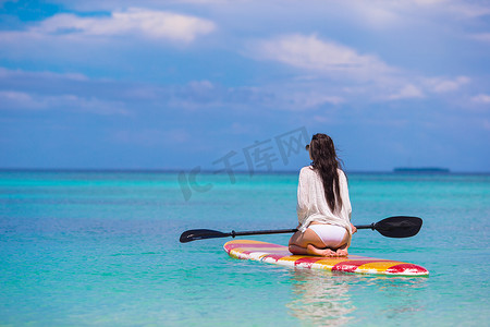 站立桨板上活跃的年轻女子