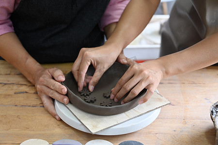 在车间装饰陶器的高级女性和年轻女性的裁剪视图.