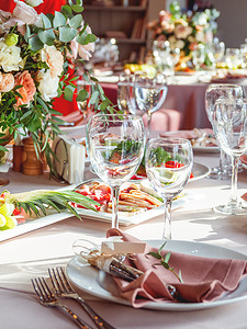 婚宴桌上配有餐具和花瓶里的鲜花。