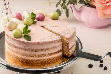 粉红色蛋糕，上面有薄荷和装饰性甜球，放在盘子上，特写。