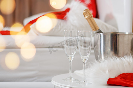 圣诞装饰的酒店房间里有两杯和一瓶香槟。