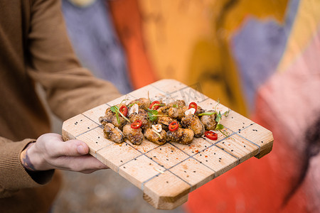 炸贻贝用辣椒、大蒜、芝麻、香草，在​​方形木板上。