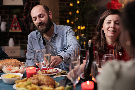 夫妇在节日晚宴上与家人一起庆祝圣诞节