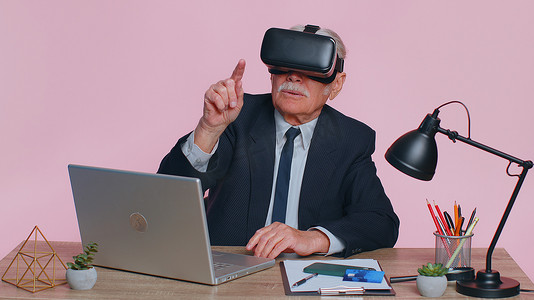 高级商人使用耳机头盔应用程序玩模拟游戏，观看虚拟现实视频