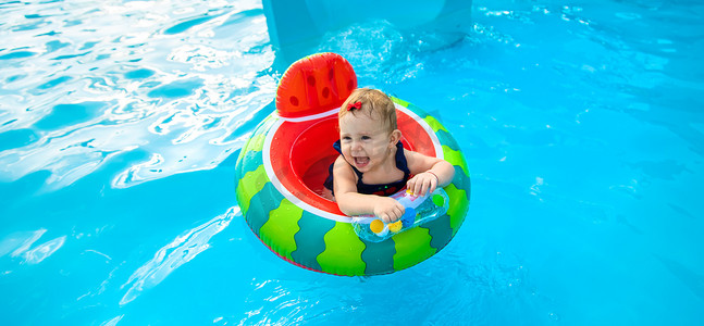 游泳小孩儿摄影照片_宝宝在泳池里绕圈游泳。