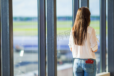 有机票和护照的快乐女孩在机场等待登机