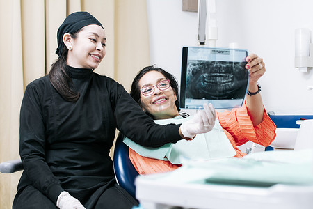 光口摄影照片_牙医与患者检查 X 光片的视图。