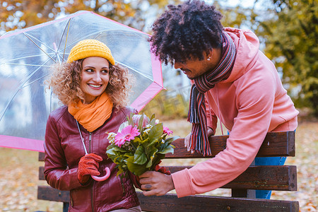 细雨蒙蒙摄影照片_在细雨蒙蒙的秋日，男人用一束鲜花给妻子一个惊喜