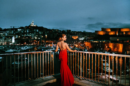 夜城马赛街头穿着红色晚礼服的优雅女孩 法国穿着红色晚礼服的女人