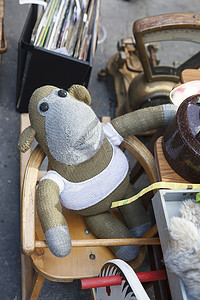穿着背心的针织猴子坐在 Spitalfields 古董市场展示的高脚椅上