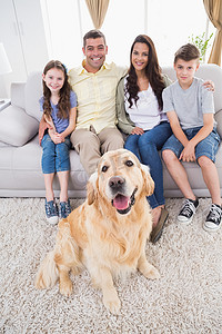 松毛汤包摄影照片_微笑的家庭与金毛猎犬的肖像