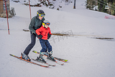 男孩在冬天在斜坡上学习滑雪、训练和听他的滑雪教练