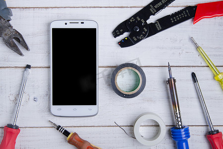 智能手机和设备维修白色木制背景。
