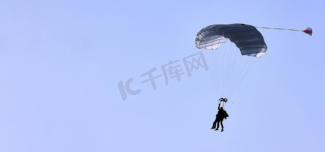 蓝天白云免费下摄影照片_一位跳伞者带着白色的降落伞，在蓝天白云的衬托下，特写。