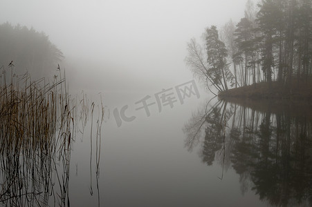 秋雾中宁静湖面的倒影