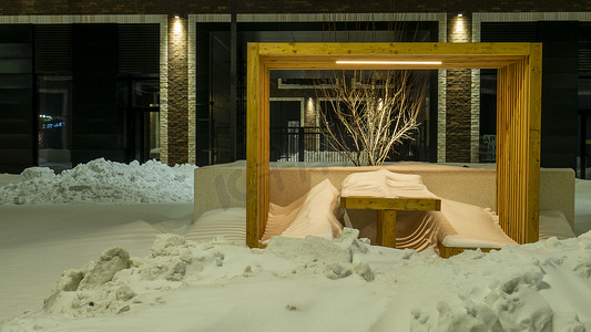 冬季暴风雨过后，莫斯科一所房子的院子里，长凳和桌子都被雪覆盖了。