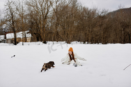 一个女人在雪地里和狗玩耍的肖像有趣的友谊生活方式