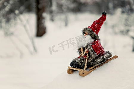 在白雪皑皑的森林里骑着雪橇的玩具圣诞老人